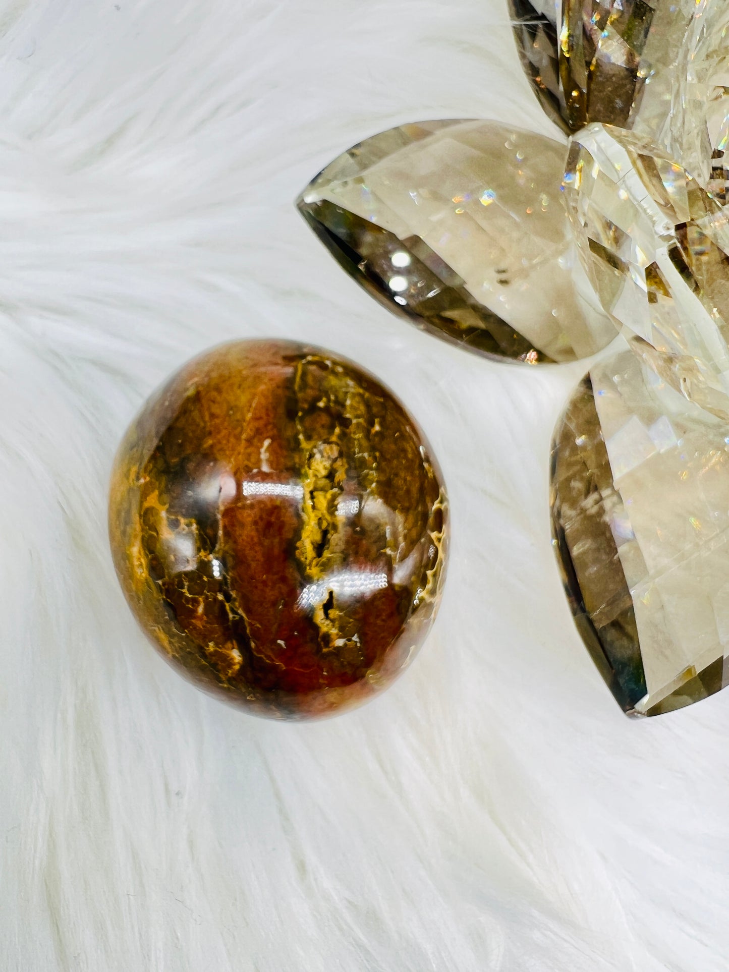 An Ocean Jasper palmstone with red and yellow and dark brown colours.