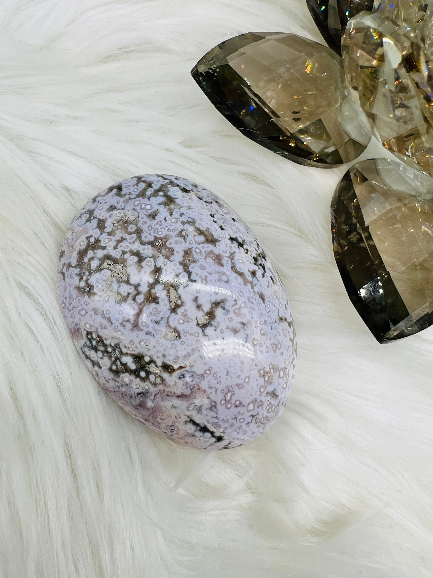 An Ocean Jasper Palmstone with lilac and yellow patterns resembling ocean waves.