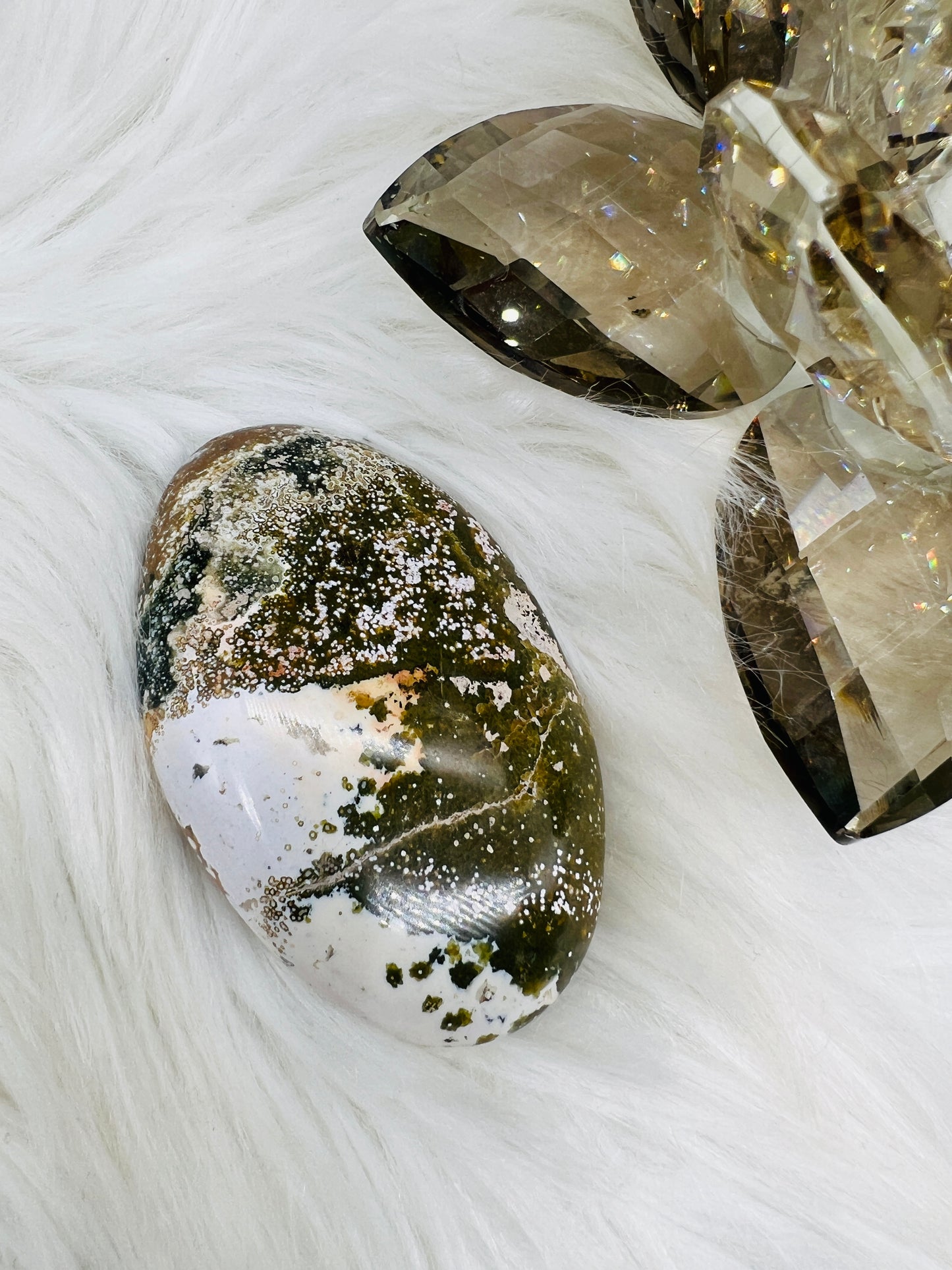 An Ocean Jasper Palmstone with patterns resembling ocean waves and sparkly quartz inclusions, green brown and white colours.