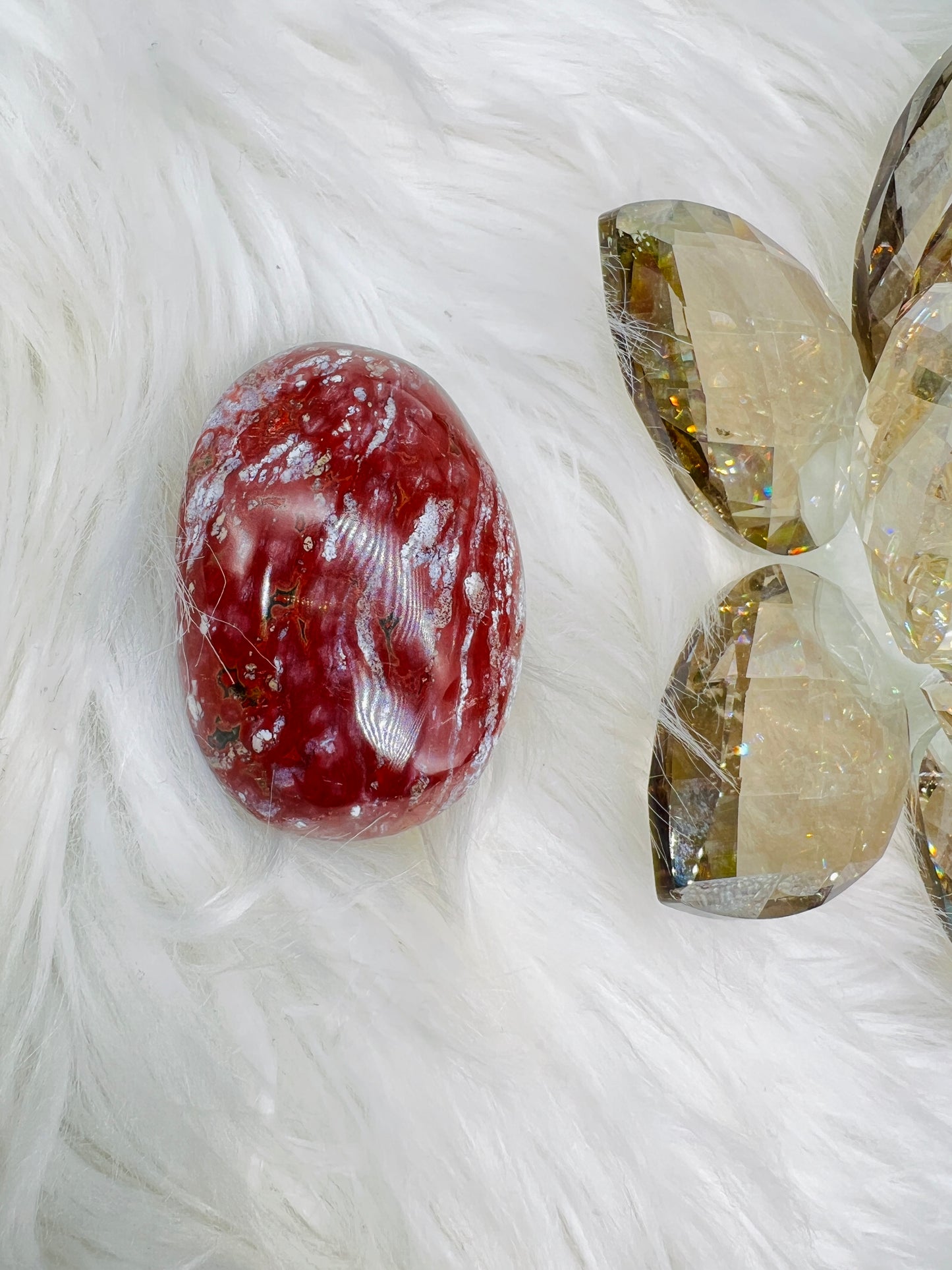An Ocean Jasper Palmstone with red and white patterns resembling ocean waves.