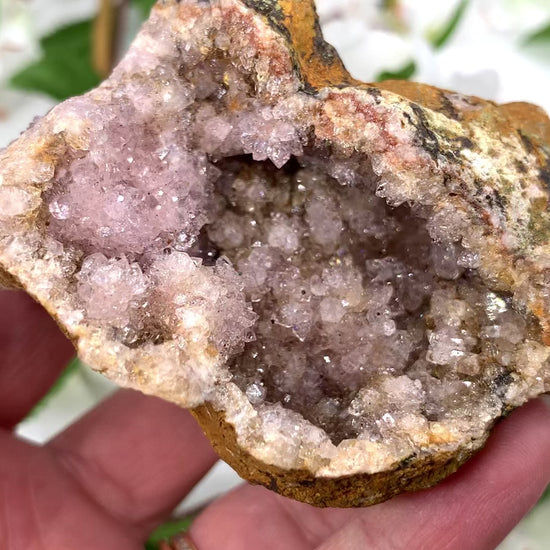 A video of a pink amethyst geode with a crystalline interior visible, surrounded by matrix, from Brazil.